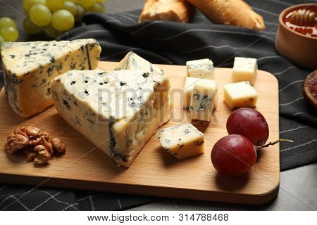 Board Of Delicious Blue Cheese With Snacks On Table