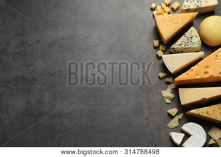 Different Delicious Cheeses On Grey Table, Top View. Space For Text