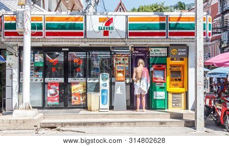 Phuket, Thailand - December 11th 2017:  Tourist At Atm Outside A 7 Eleven Shop In Patong. Convenienc