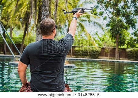 A Sympathetic Man Launches A Drone For Flight, With Which You Can Take Photos And Videos, Near The S