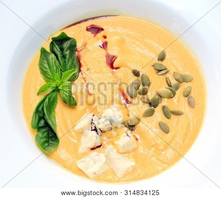 Cheese Soup Closeup In A White Plate On A White Background.