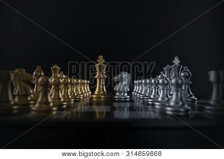 Silver Chess Knight Is Facing Golden Chess King On Black Background. Business Strategy, Market Share