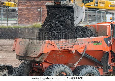 Sheffield, Uk - 1st August 2019: A Digger And Dump Truck Move Dirt To Make Room For The Foundations 