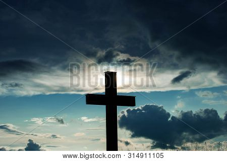 Simple Oak Catholic Cross After Heavy Rainstorm, Dramatic Blue Sky With Stormclouds.