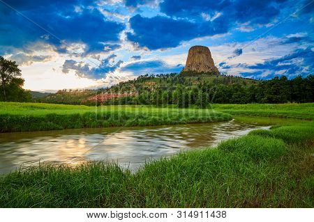 Sunset At Devils Tower National Monument With The Belle Fourche River In The Foreground.