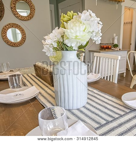 Square Table Setting Inside A Dining Room With Brown Table And White Chairs