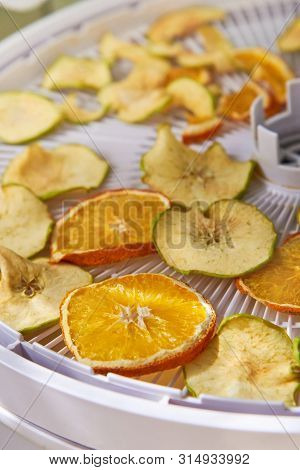 Apple And Orange Chips Cooked In A Dehydrator, Close-up. The Theme Of Healthy Eating