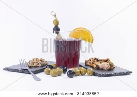 Traditional Spanish Appetizer. A Glass Of Vermouth Decorated With Olives, And Assorted Tapas.