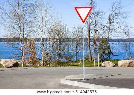 Road Sign - Give Way, On A Background Of Blue Lake