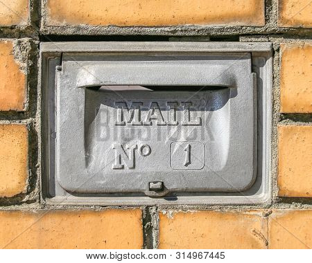 Retro Mailbox Wall Mounted. Postbox For Letters With Number One. Yellow Brick Wall On Background
