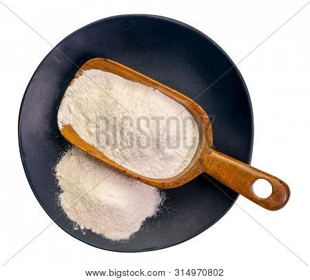 Cassava (yuca) flour on a wooden scoop and plate. It is a gluten free and grain free replacement for wheat flour.
