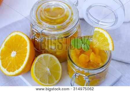 Pumpkin Jam Or Marmalade With Orange And Lemon. Two Glass Jars Of Pumpkin Jam. Still Life Is Decorat