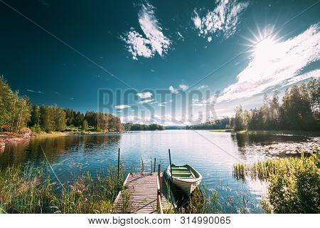 Old Wooden Fishing Boat Moored Near Pier In Summer Lake Or River. Beautiful Summer Sunny Day Or Even