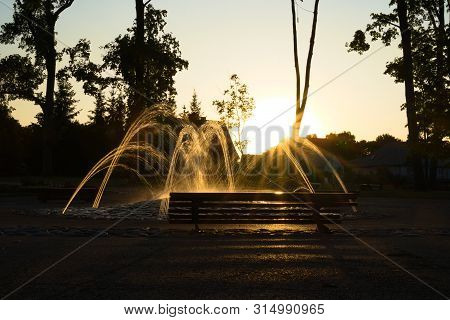 Europe, Lithuania, Marijampole, Poetry Park Fountain Infront Of Evening Sun