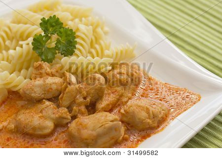 HÃ¤hnchenstÃ¼cke mit Nudeln in Paprika-Sahne-Sauce. horizontal.