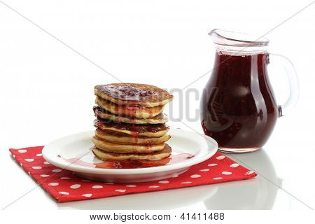 หวาน pancakes บนแผ่นกับนมข้นที่แยกต่างหากบนพื้นสีขาว