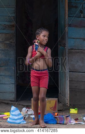 Darien Province, Panama. 07-18-2019. Portrait Of Smiling Afro-descendent Girl Carrying A Baby Doll I