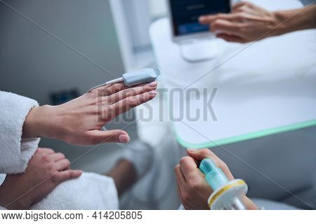 Patient Having Her Oxygen Saturation Level Measured By A Pulmonologist