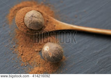 Nutmeg .whole And Ground Nutmeg In A Wooden Spoon On A Schiffer Background. And Herbs Concept.food I