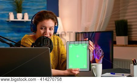 Influencer Holding Tablet With Green Screen Display
