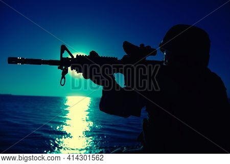 Modern Army Infantry Soldier, Coast Guard Rifleman Aiming Assault Rifle With Collimator Sight At Nig
