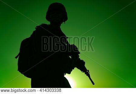 Silhouette Of Army Rifleman In Helmet And Ammunition, Carrying Tactical Backpack, Walking With Servi