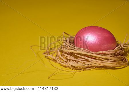 Pearl Colored Egg In The Nest On A Yellow Background. Easter Concept.