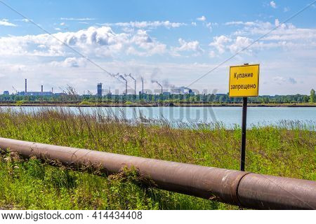Warning Sign - Swimming Is Prohibited Near Pipeline, Behind Which There Is A Lake, And Then Many Chi