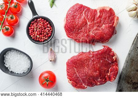 Raw Rumpsteak, Farm Beef Meat With Seasonings, Rosemary, Garlic And Butcher Cleaver. White Textured 