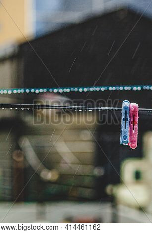 Two Clothespins - Blue And Pink. Hang Ode To The Rain On The Street In The City, Raindrops Are Clear