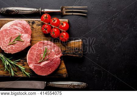 Two Fresh Parisienne Raw Steak On Wooden Board With Salt, Pepper And Rosmary In A Rustic Style On Ol