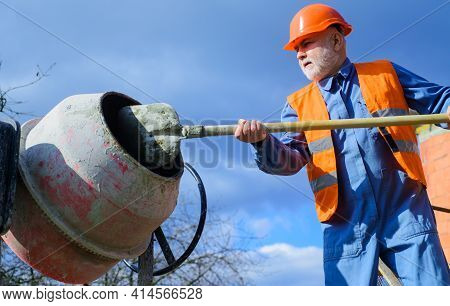 Construction Worker Works With Concrete Mixer. Cement Creation. Builder Prepares Cement Mortar.