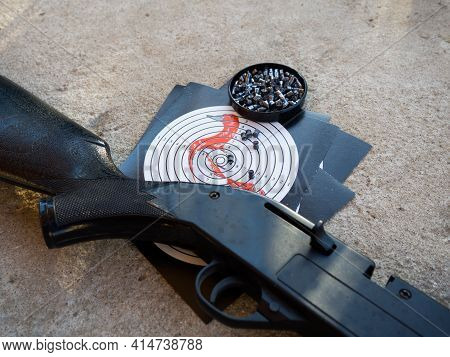 A Target For Shooting And The Barrel Of An Air Rifle. Shooting Target With Bullets And Rifle Barrel