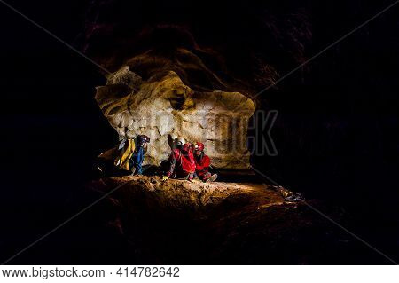 Speleologists Exploring A Deep Cave