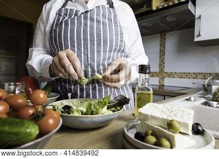 Woman Prepare Greek Salad In Your Kitchen. Home Made Cooking Greek Salad .