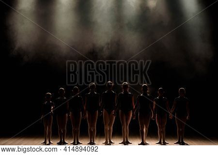 Ballet Class On The Stage Of The Theater With Light And Smoke. Children Are Engaged In Classical Exe