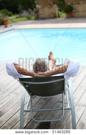 Back view of senior man reaxing in long chair