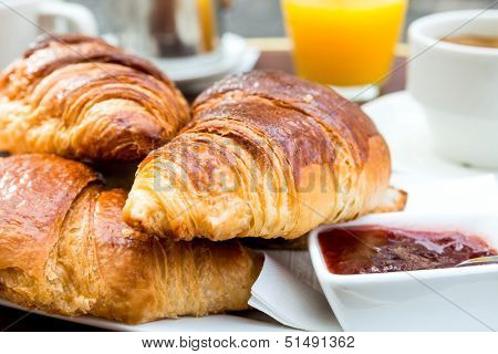 Breakfast with coffee and croissants on table