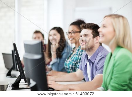 education concept - students with computers studying at school
