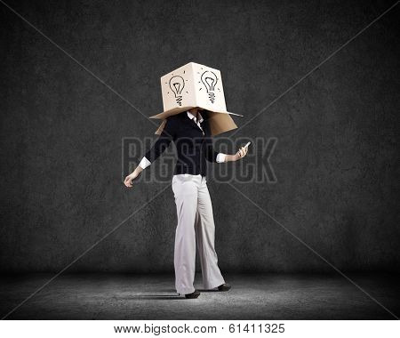 Businesswoman using mobile phone wearing carton box on head