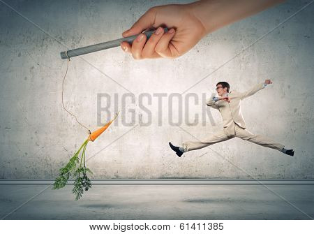 Funny image of businessman chased with carrot
