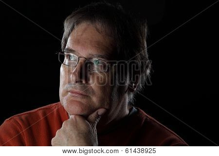 Mature Man Looks Quizzical - On Black Background With Dramatic Lighting
