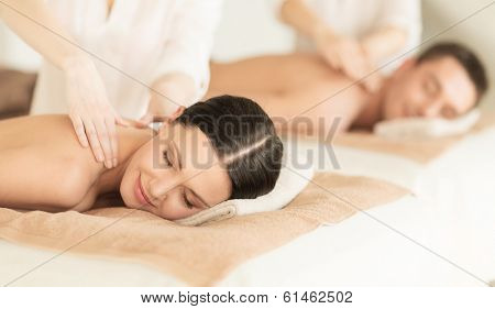 healthcare and beauty concept - picture of couple in spa salon getting massage