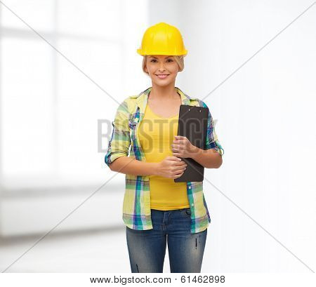 repair, construction and maintenance concept - smiling woman in helmet with clipboard