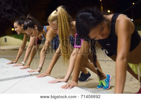 Group Of Girls Doing Push-ups At Night.