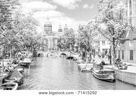 Tourists walking by a canal in Amsterdam