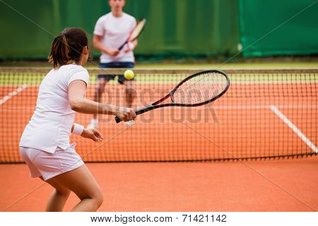 Tennis players playing a match on the court on a sunny day