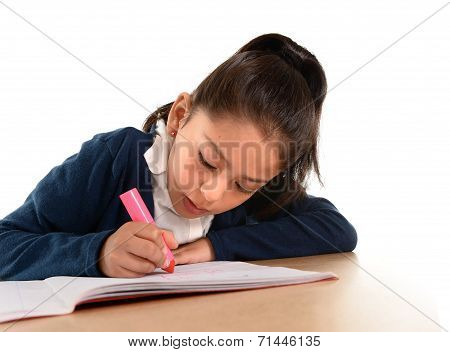 Little Hispanic Female Child Writing And Doing Homework With Pink Marker