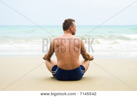 mand sidder på stranden