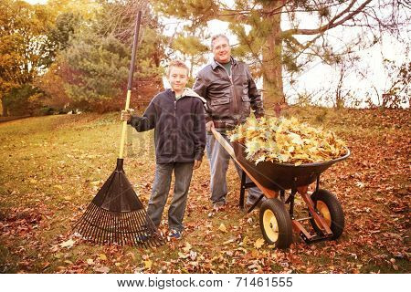 Father and son raking leaves 